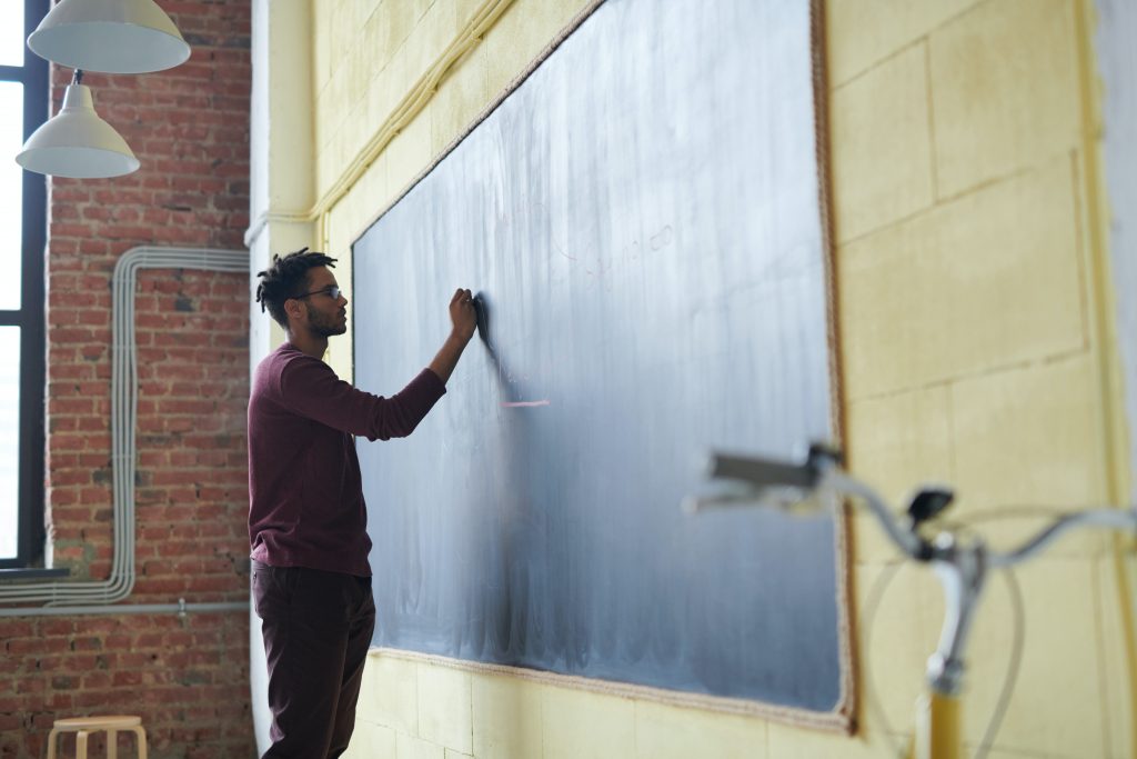 Teacher writing on a blackboard