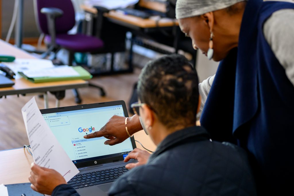 Teacher and student looking at a laptop in a classroom