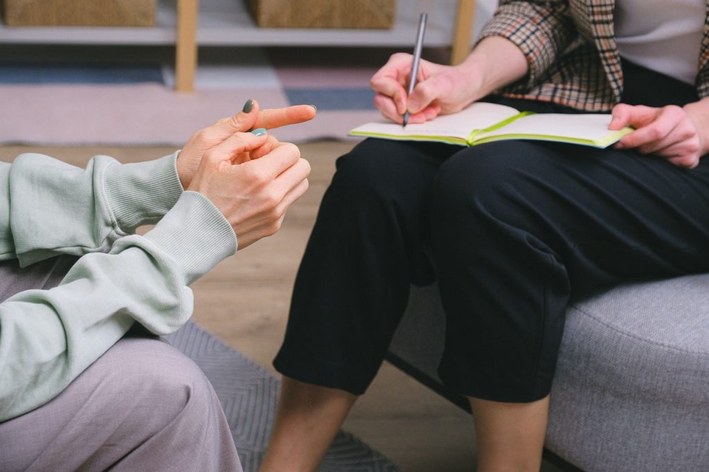 Woman taking notes during a therapy session.